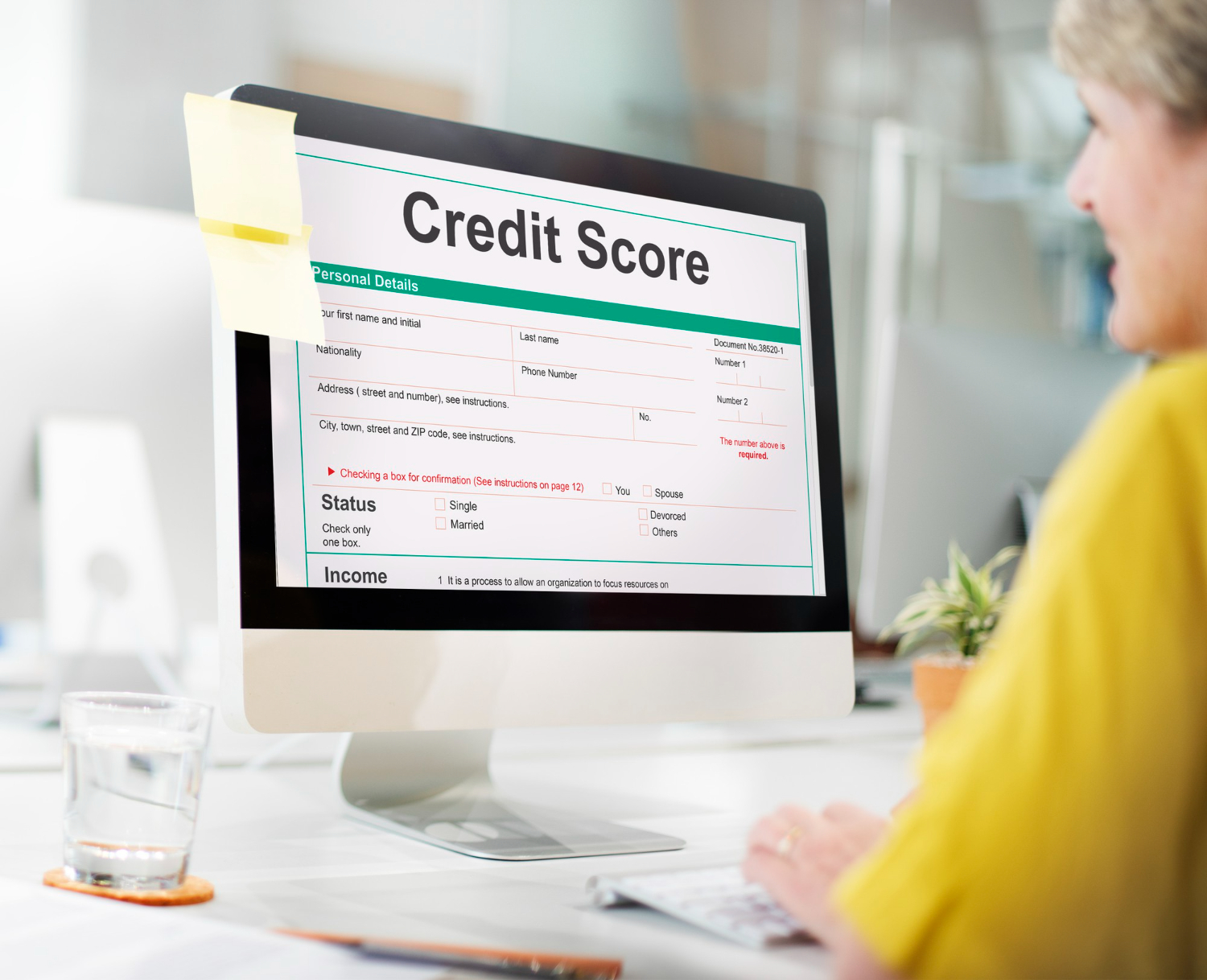 A person reviewing a credit score report on a computer screen, highlighting personal details and credit status information.